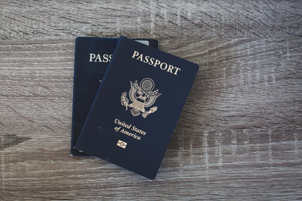 Free Image of Two blue passports on a wooden surface 