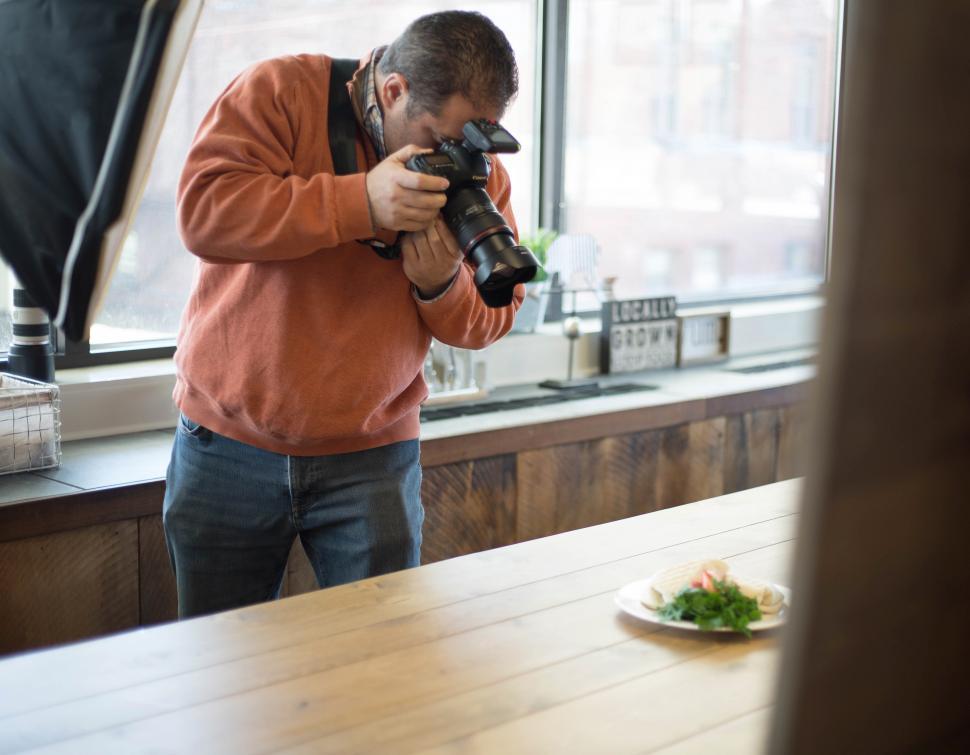 Free Image of A man taking a picture of food 