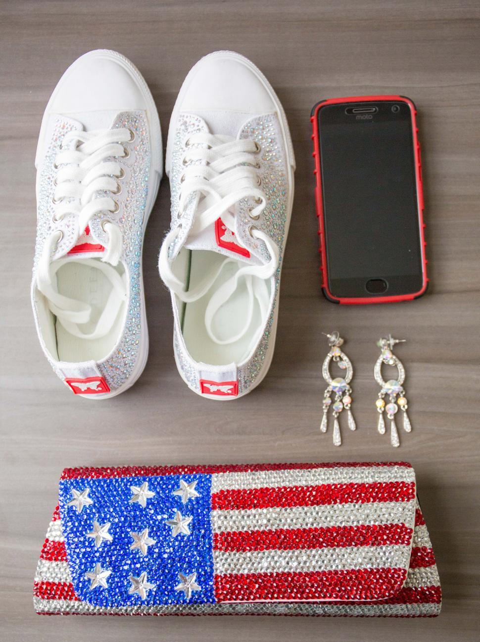 Free Image of A pair of shoes and a phone next to a purse and earrings 