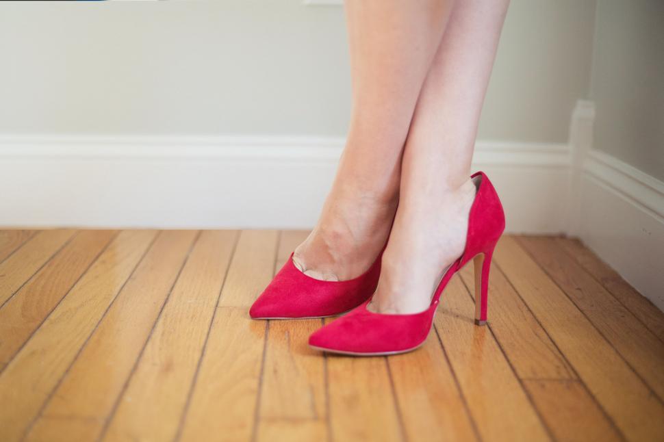 Free Image of A pair of legs wearing red high heels 