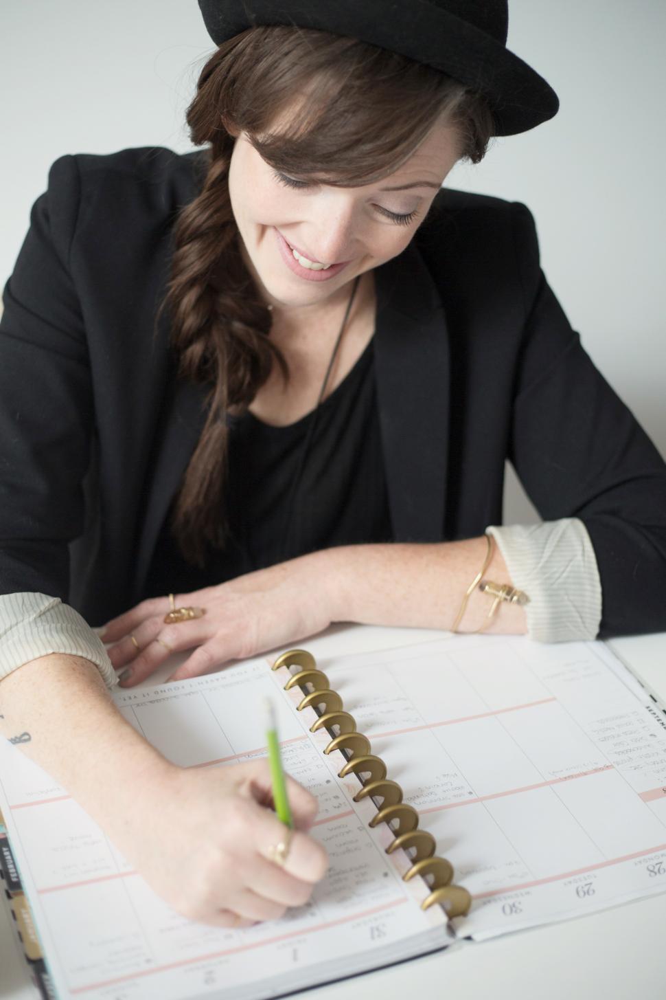 Free Image of A woman writing on a calendar 