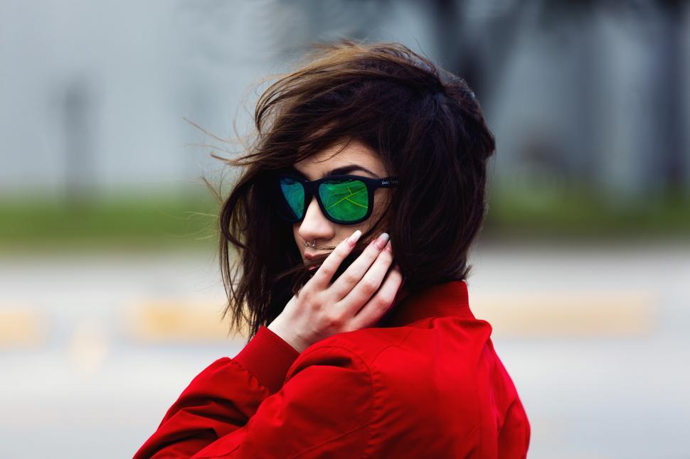 Free Image of A woman wearing sunglasses and red jacket 