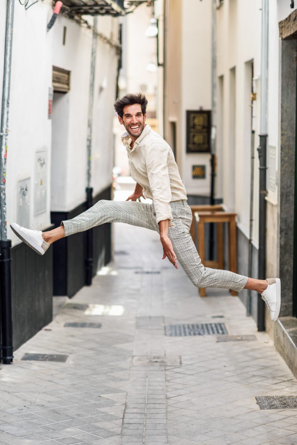 Free Image of Young happy man jumping in the street. 