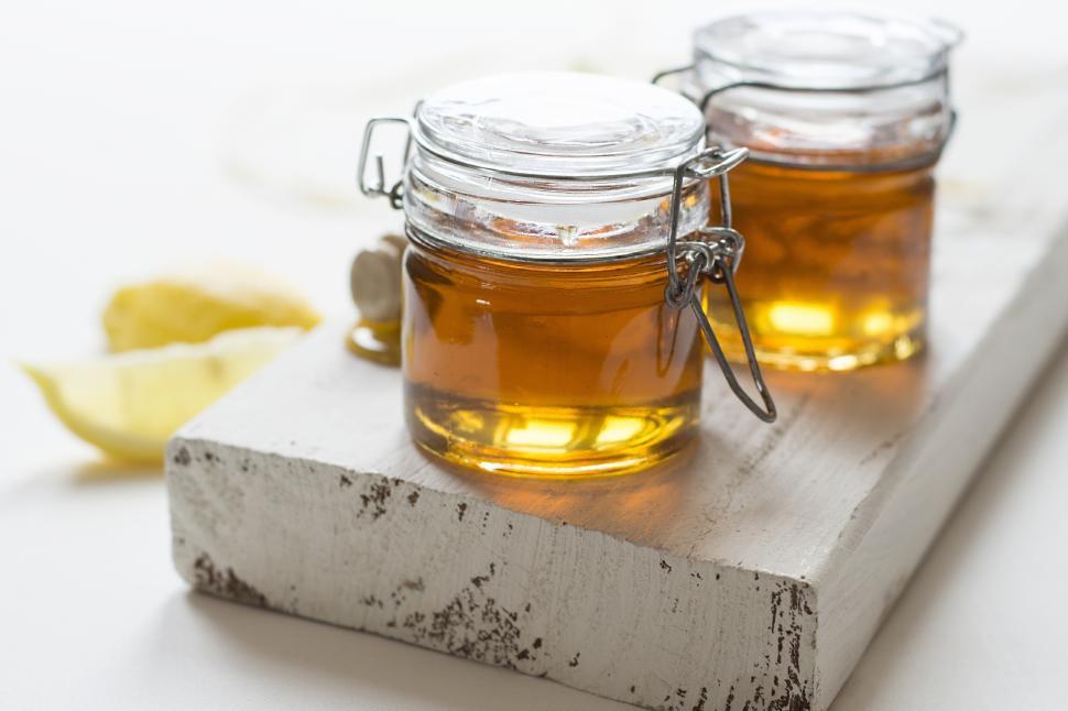 Free Image of A jar of honey on a block 