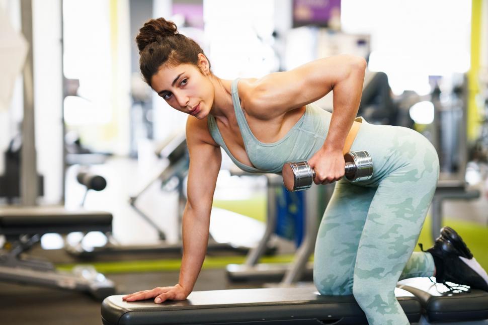 Free Image of Woman working on her triceps and biceps in a gym with dumbbells 