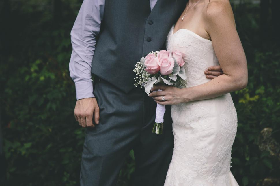 Free Image of A man and woman in a suit holding flowers 