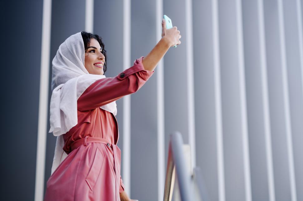 Free Image of Muslim Woman with hijab taking selfie with smartphone 