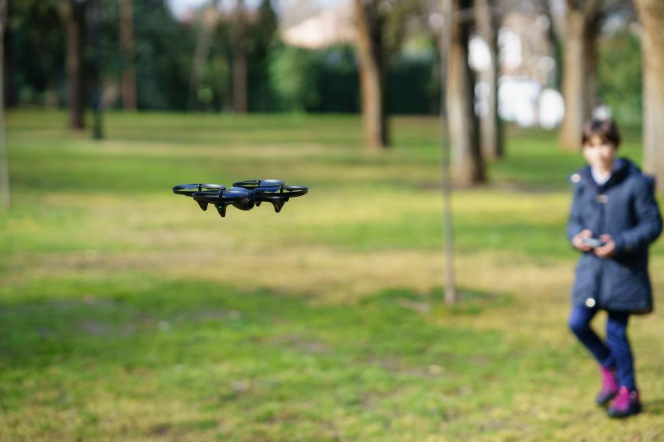 Free Image of Nine-year-old girl operating toy drone flying by remote control 