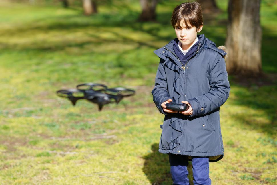Free Image of Nine-year-old girl pilots toy drone flying by remote control 