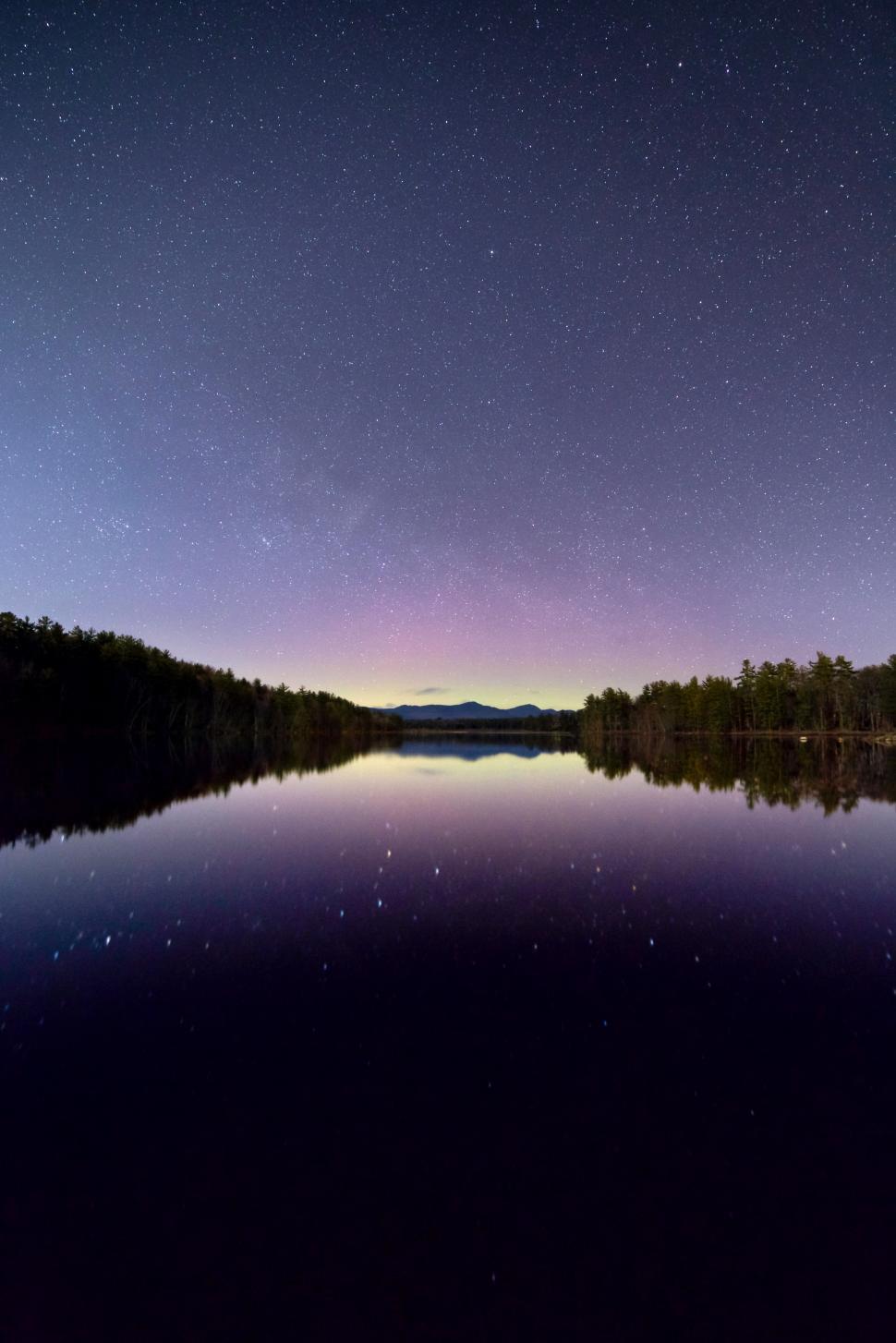 Free Image of A lake with trees and stars in the sky 