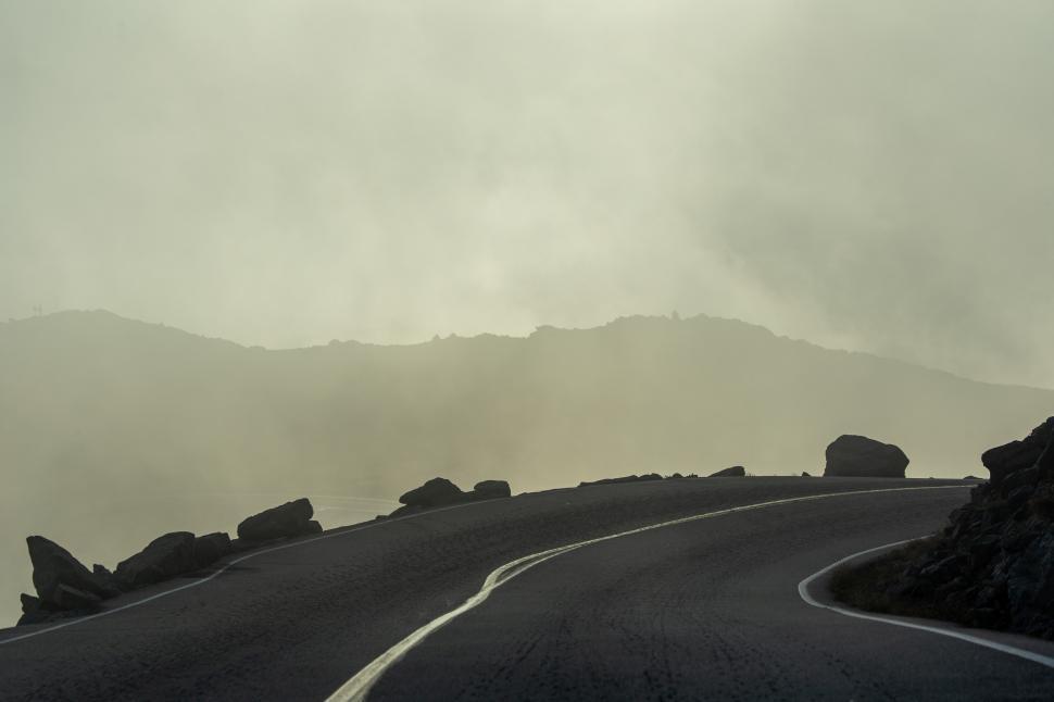 Free Image of A winding road with rocks in the background 