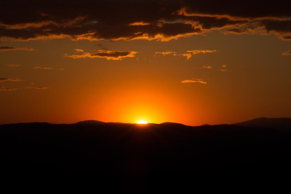 Free Image of A sunset over a mountain 