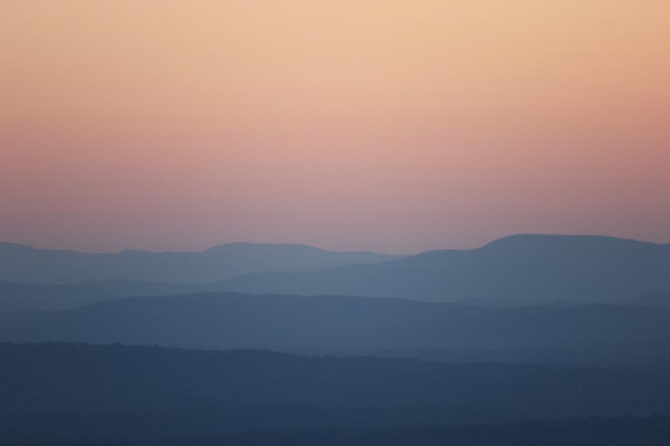 Free Image of A landscape of mountains and a pink sky 