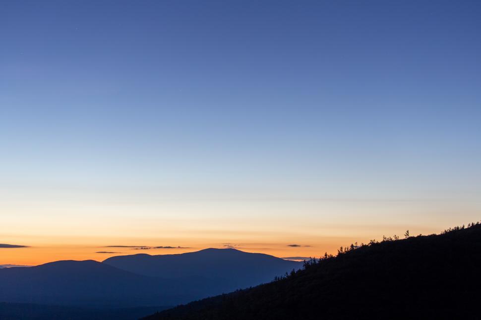 Free Image of A sunset over a mountain 