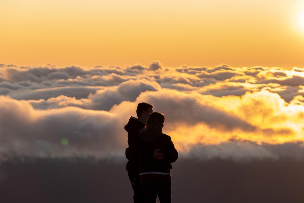 Free Image of A man and woman hugging on a mountain 