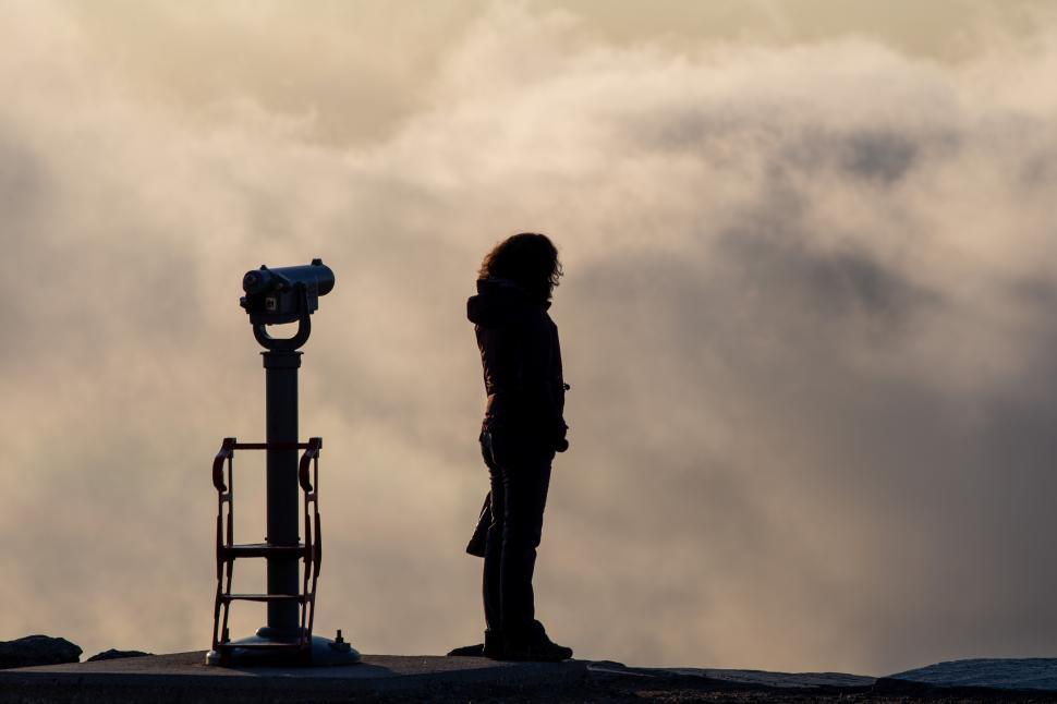 Free Image of A silhouette of a woman looking at a telescope 