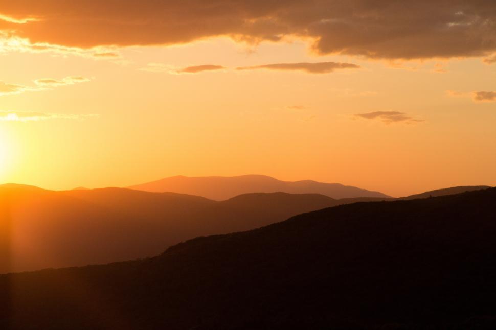 Free Image of A sunset over a mountain range 