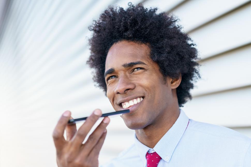 Free Image of Black Businessman using a smartphone near an office building 