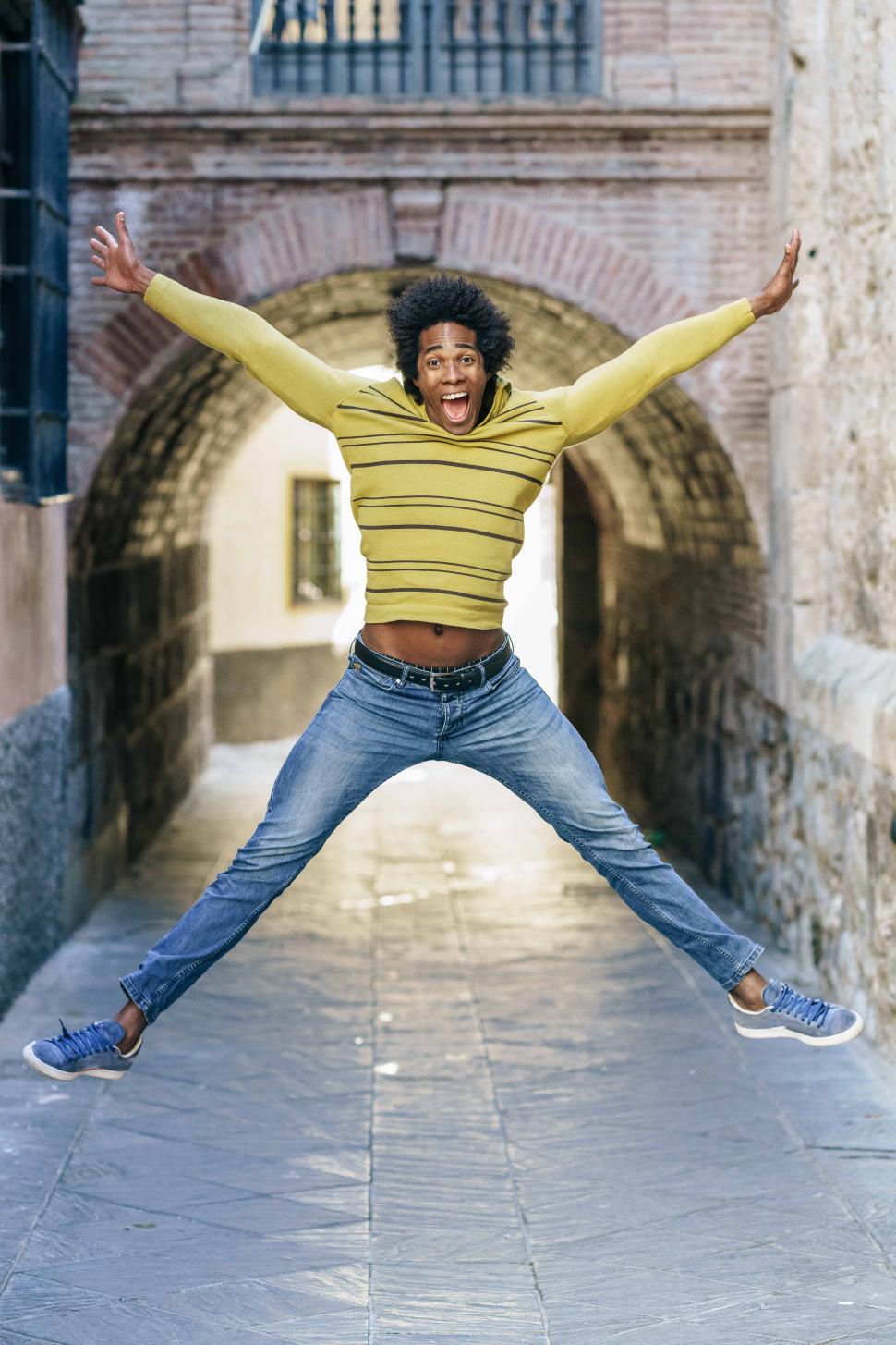 Free Image of Black man with afro hair jumping for joy 