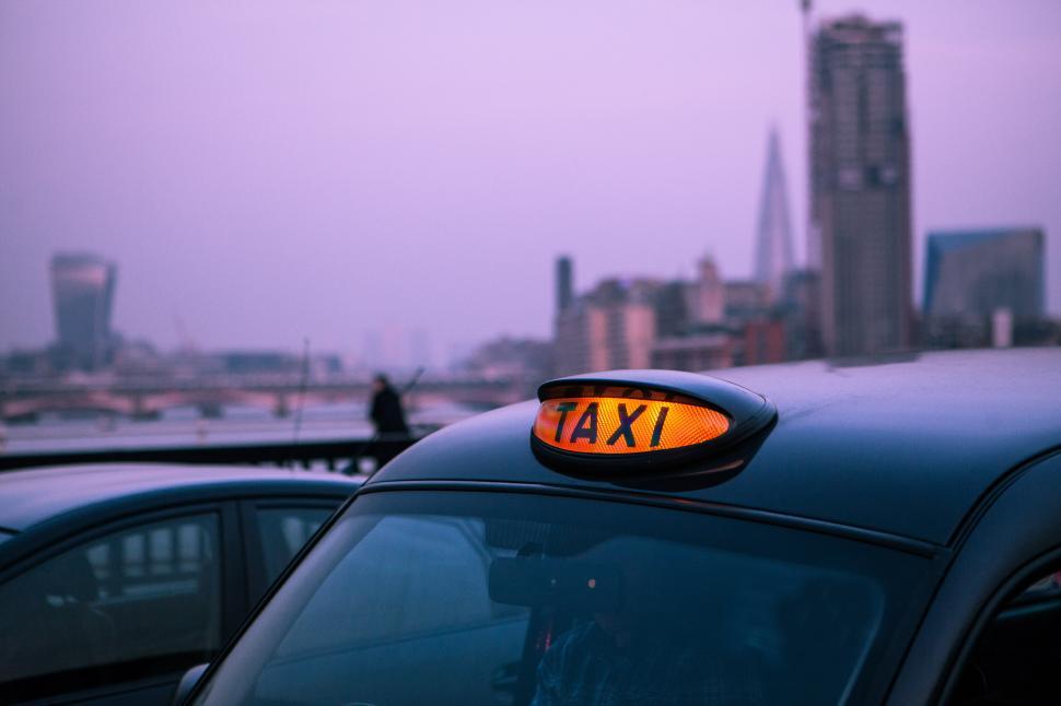 Free Image of A taxi sign on top of a car 