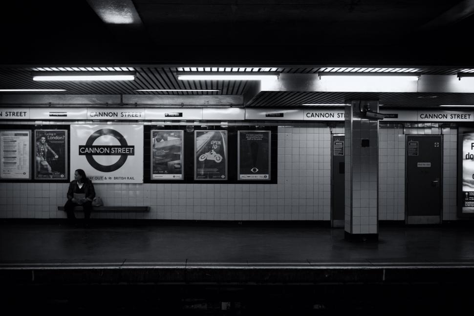 Free Image of A person sitting on a bench in a subway station 