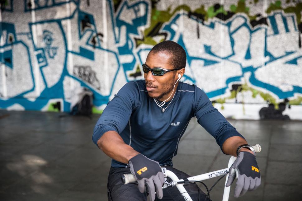Free Image of A man wearing sunglasses and riding a bike 