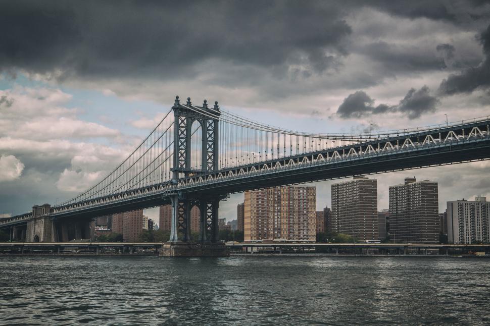 Free Image of A bridge over water with buildings in the background 