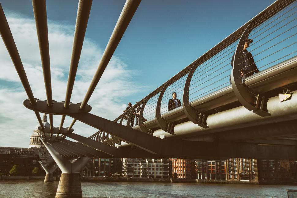 Free Image of A group of people on a bridge over water 