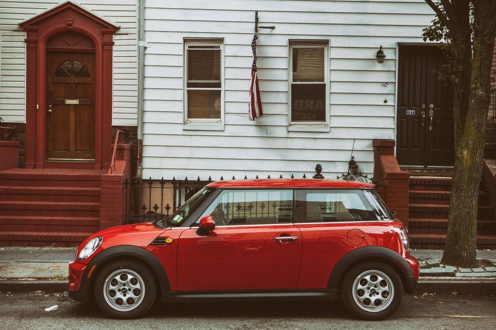 Free Image of A red car parked in front of a house 