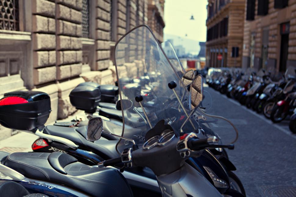 Free Image of A row of motorcycles parked on a sidewalk 