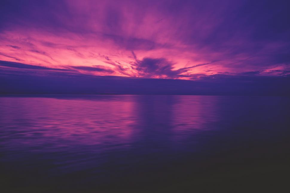 Free Image of A purple and pink sky over water 