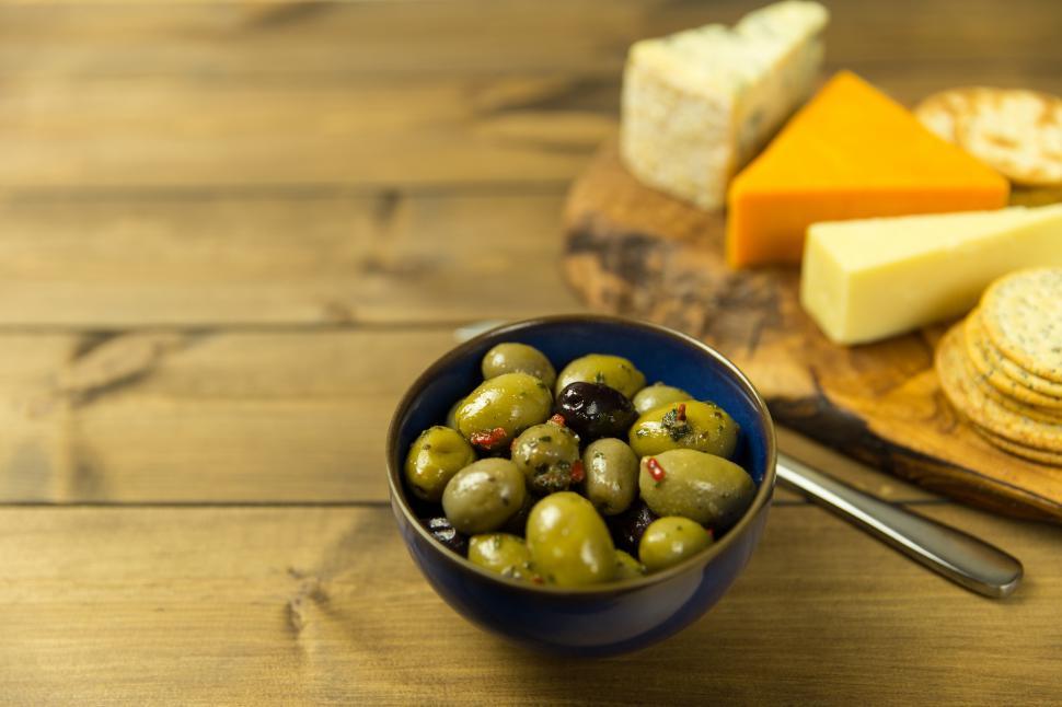 Free Image of A bowl of green olives and cheese 