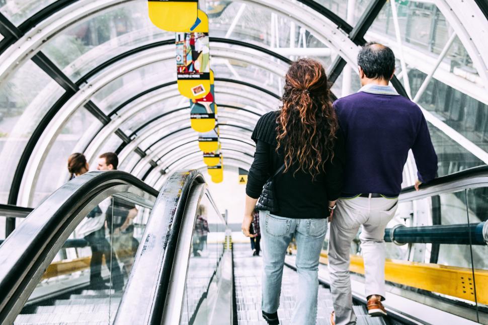 Free Image of A man and woman walking on an escalator 