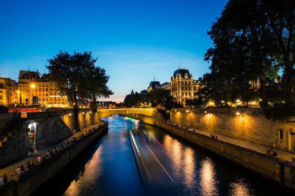 Free Image of Seine river in Paris France with lights on it and a building in the background 