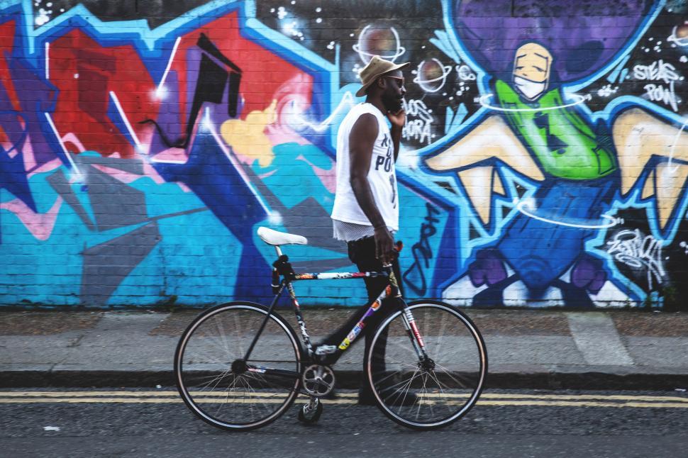 Free Image of A man standing next to a bicycle 