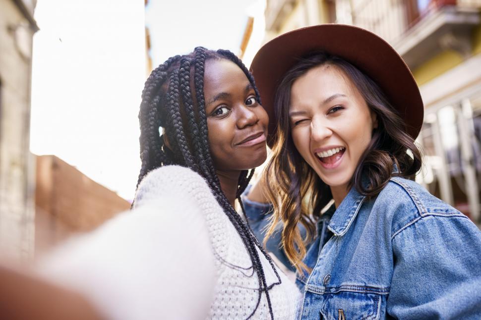Free Image of Two beautiful multiethnic women making selfie and grimacing 
