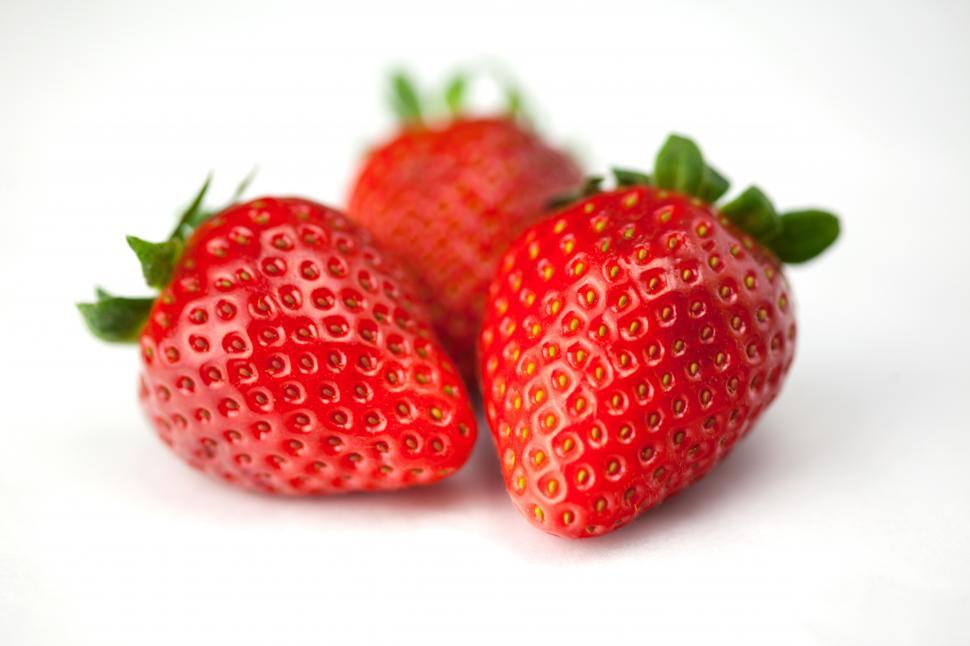 Free Image of A group of strawberries on a white surface 