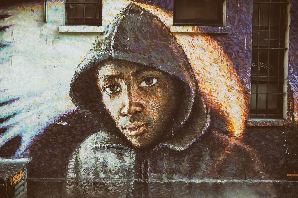 Free Image of A mural of a boy in a hoodie on a building 