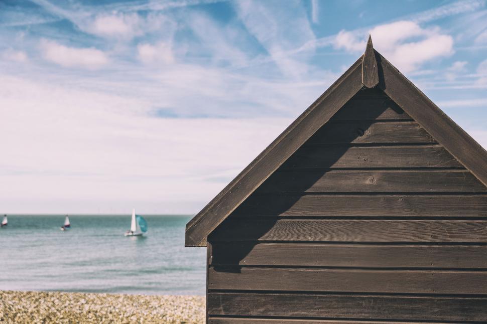 Free Image of A wooden building with a sailboat in the water 