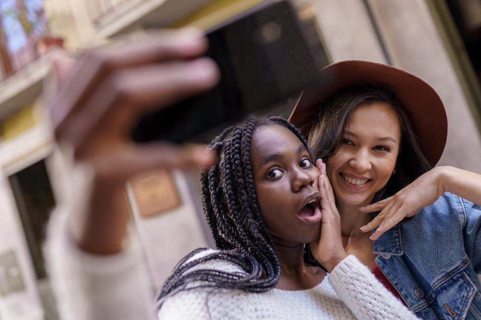 Free Image of Two beautiful multiethnic women making selfie and grimacing 