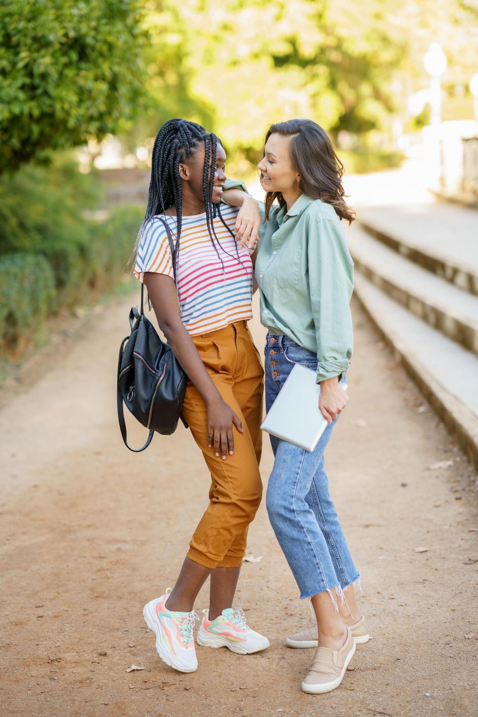 Free Image of Two multiethnic women posing together with colorful casual clothing 
