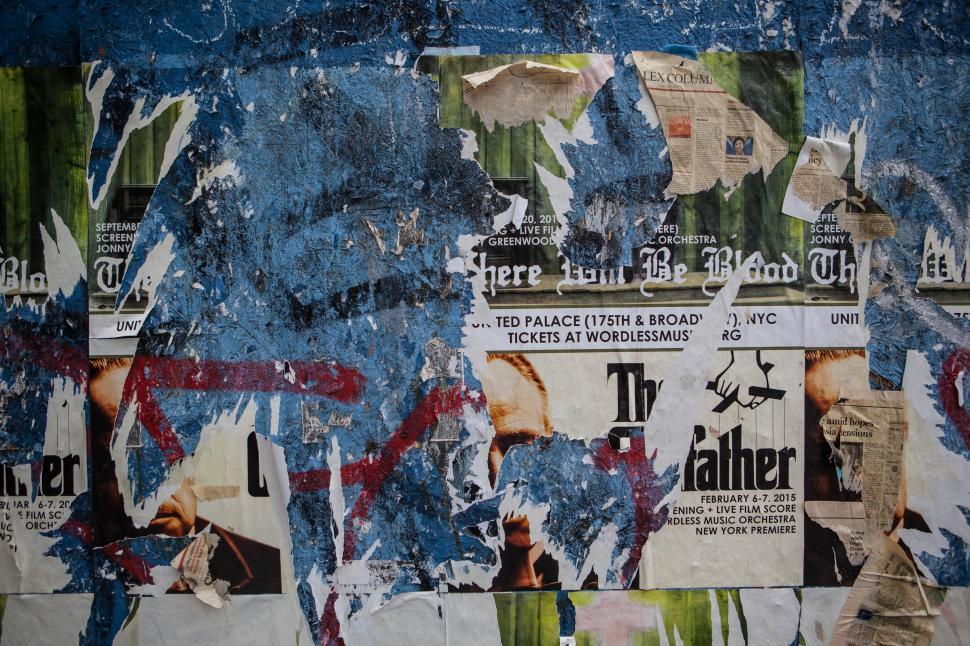 Free Image of A wall with torn posters 
