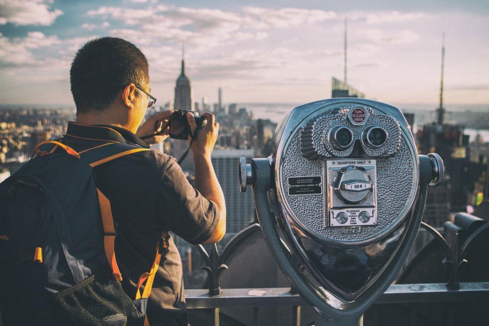 Free Image of A man taking a picture of a city 