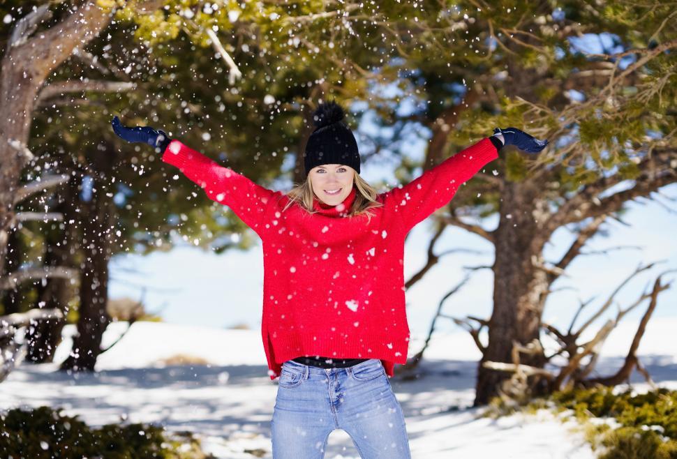 Free Image of Woman throwing snowballs in a snowy forest in the mountains 