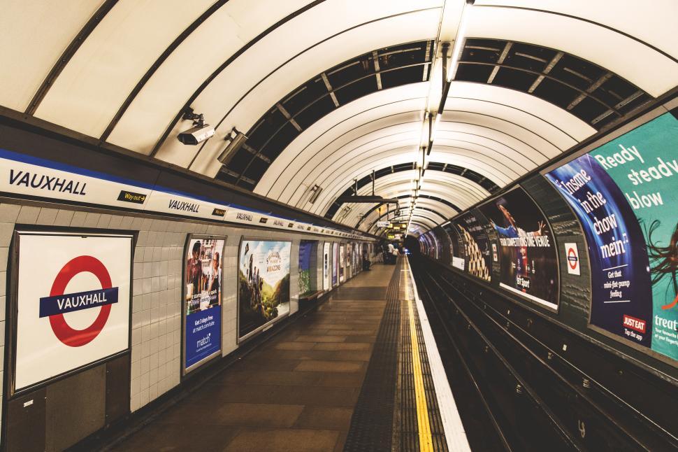 Free Image of A subway station with a train and billboards 