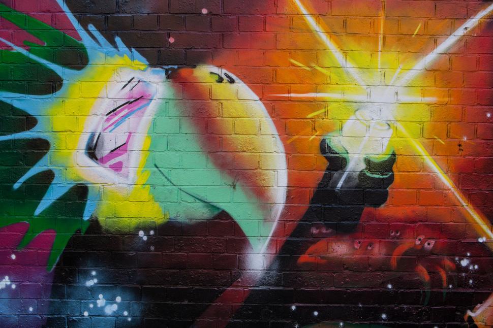 Free Image of A wall with a colorful painting of a bird holding a light 