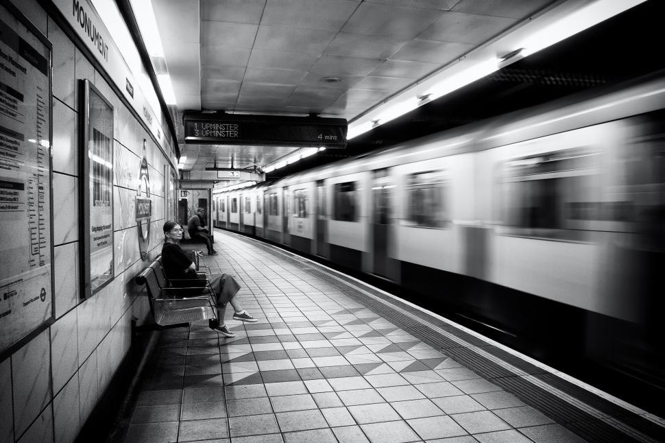 Free Image of A man sitting on a bench in a subway station 