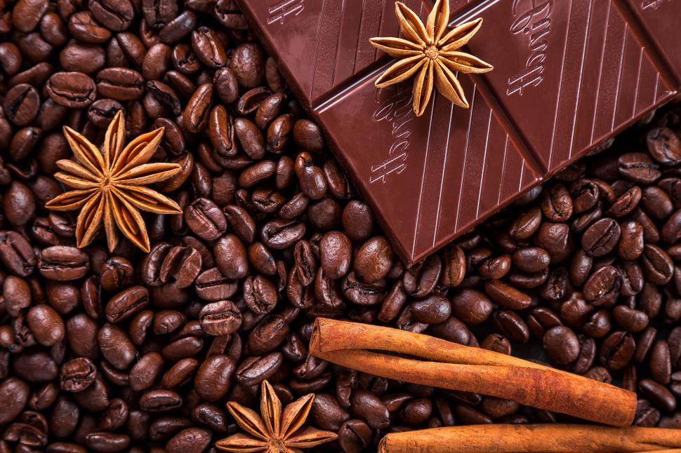 Free Image of A chocolate bar and cinnamon sticks on coffee beans 