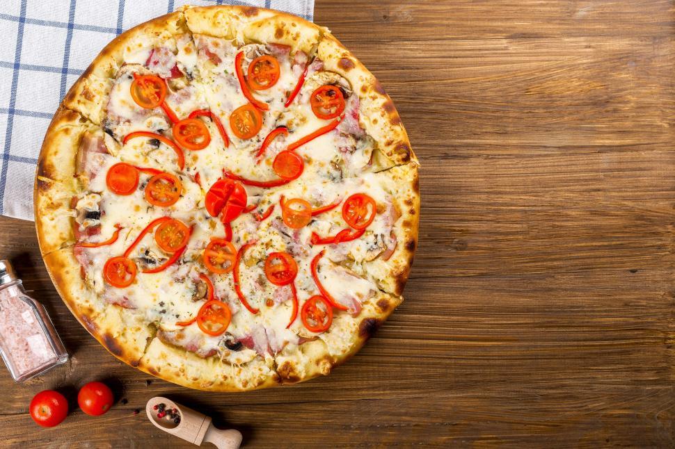 Free Image of A pizza with tomatoes on top 