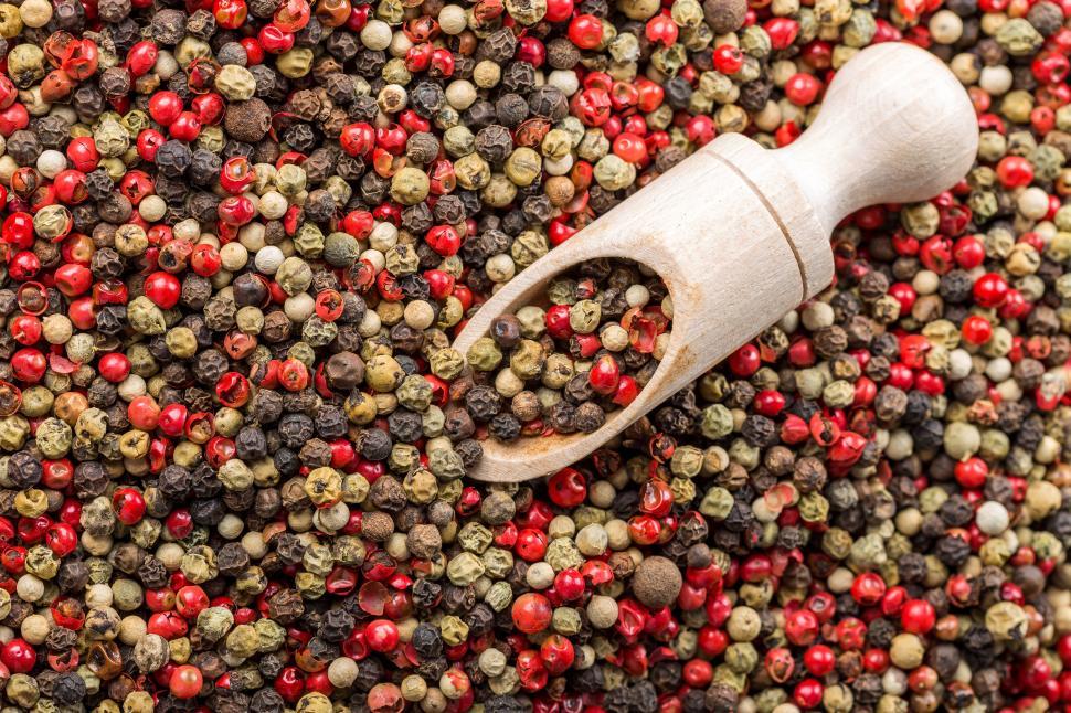 Free Image of A wooden spoon in a pile of peppercorns 